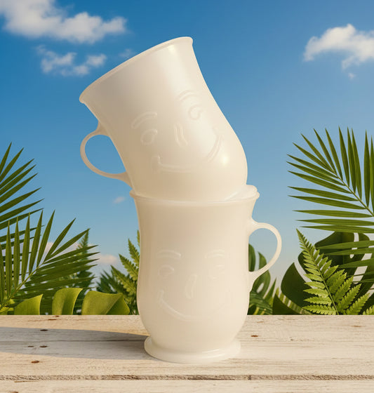 Two white ceramic cups stacked on a patterned surface